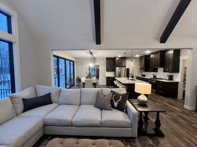 living room with sink, a chandelier, dark wood-type flooring, and beamed ceiling