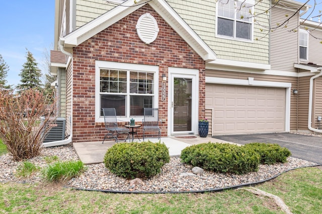 property entrance with central AC unit and a garage