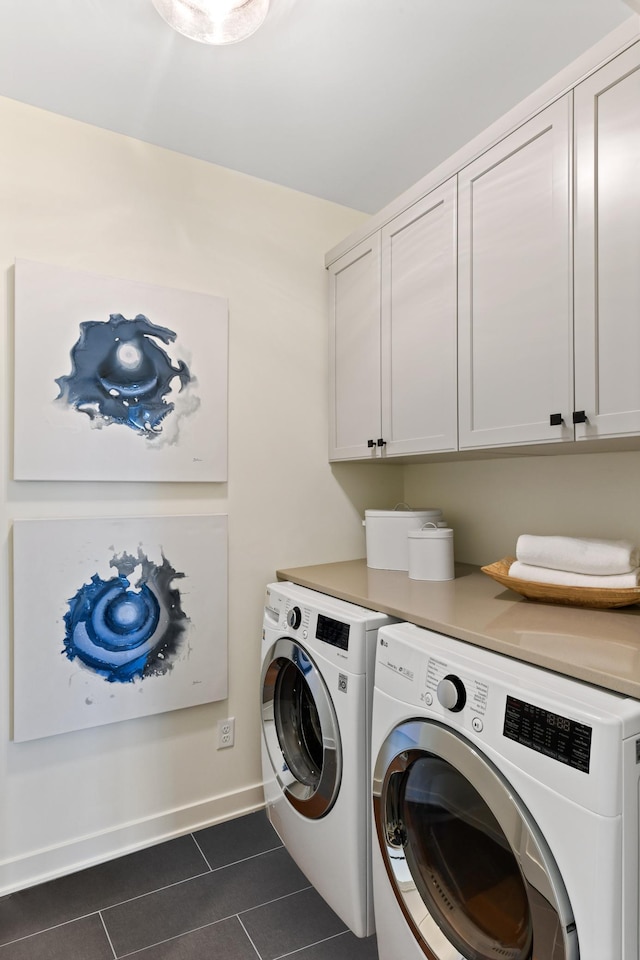 laundry area featuring cabinets, separate washer and dryer, and dark tile patterned flooring