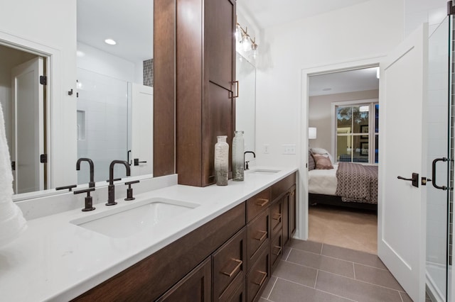 bathroom featuring tile patterned flooring, vanity, and a shower with door