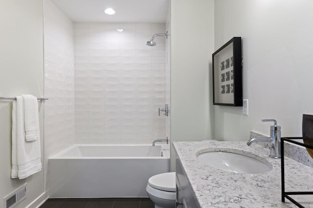 full bathroom with vanity, tiled shower / bath, tile patterned floors, and toilet