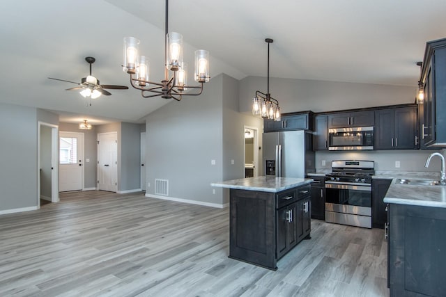 kitchen featuring light hardwood / wood-style floors, a kitchen island, ceiling fan with notable chandelier, stainless steel appliances, and decorative light fixtures