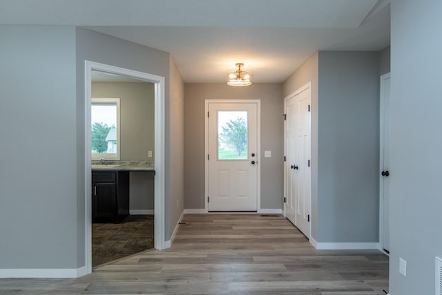 foyer entrance featuring a chandelier and light wood-type flooring