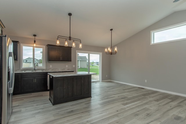 kitchen featuring hanging light fixtures, a center island, stainless steel fridge, and light wood-type flooring