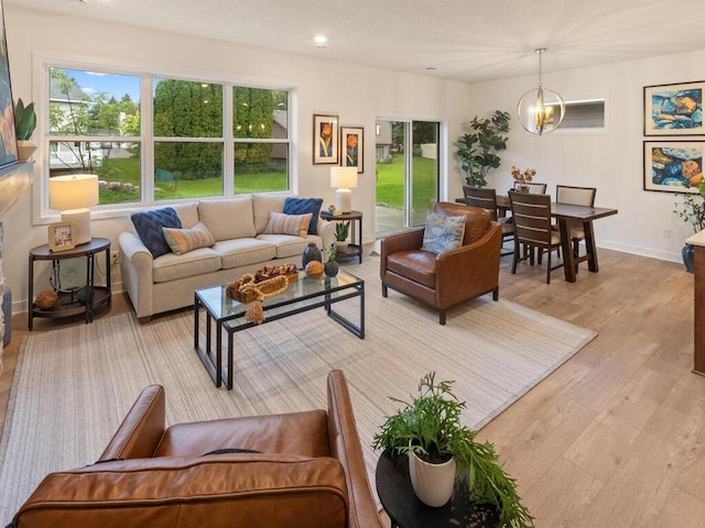 living room featuring a chandelier and light wood-type flooring