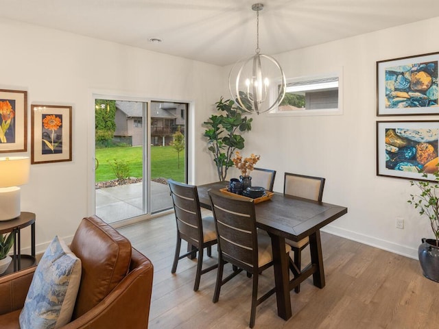 dining area featuring wood-type flooring and an inviting chandelier