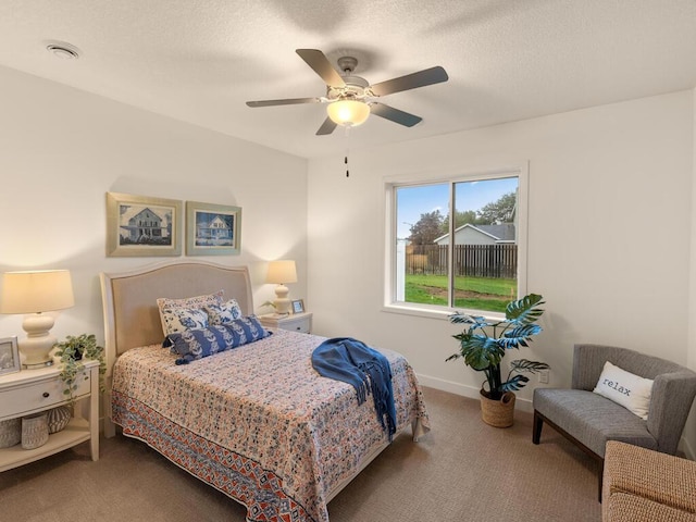 carpeted bedroom featuring a textured ceiling and ceiling fan