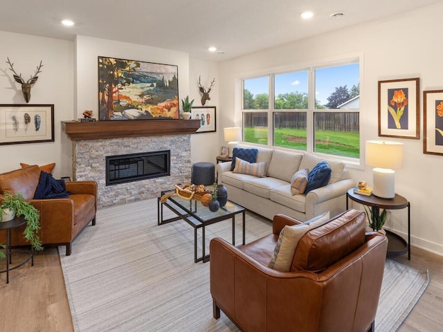 living area with recessed lighting, a fireplace, light wood-style flooring, and baseboards