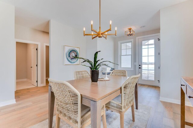 dining space featuring light hardwood / wood-style floors and an inviting chandelier