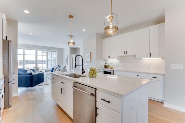 kitchen featuring white cabinetry, a kitchen island with sink, and sink