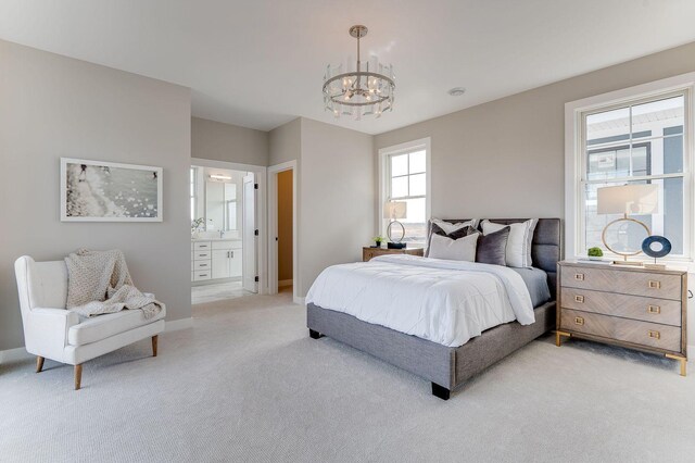 carpeted bedroom with a chandelier and ensuite bath