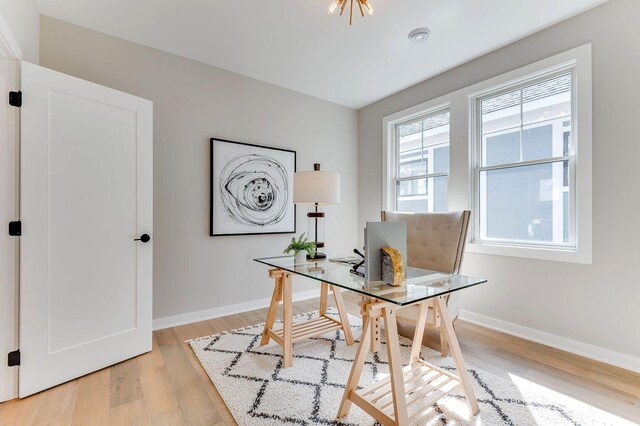 home office with light hardwood / wood-style flooring