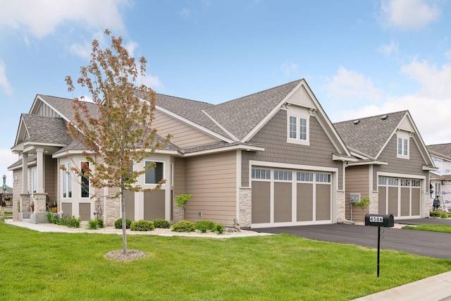 craftsman house with a garage and a front lawn