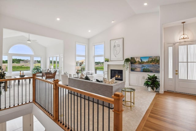 living room with light wood-type flooring, vaulted ceiling, and ceiling fan