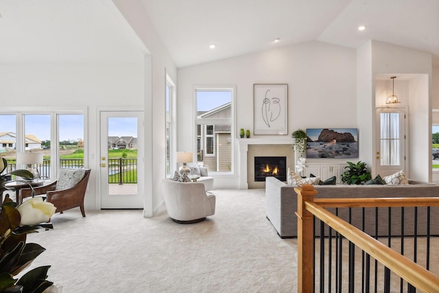 living room with lofted ceiling, carpet floors, and a healthy amount of sunlight