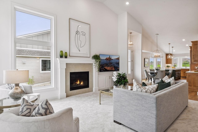 carpeted living room featuring a tile fireplace, vaulted ceiling, and sink