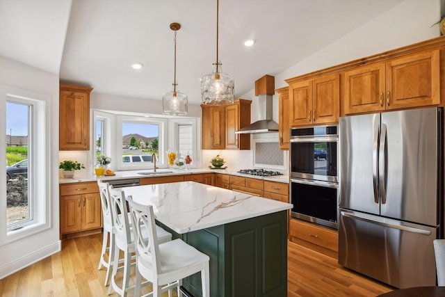 kitchen with tasteful backsplash, wall chimney exhaust hood, stainless steel appliances, a center island, and lofted ceiling