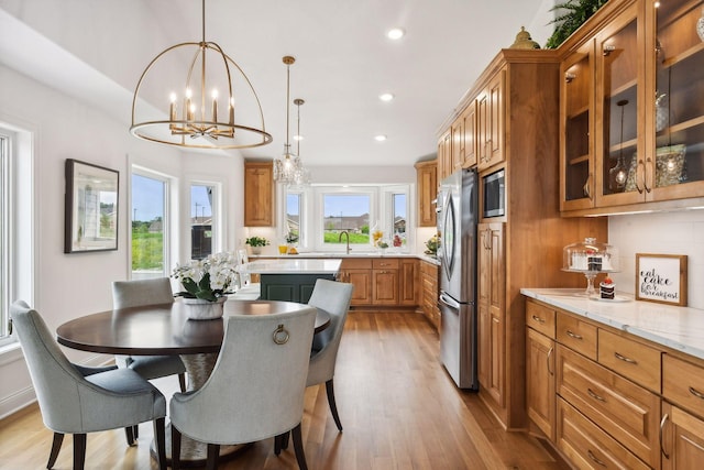 kitchen featuring built in microwave, a notable chandelier, stainless steel fridge, decorative light fixtures, and decorative backsplash