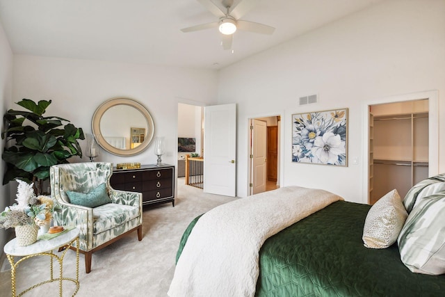 bedroom with a spacious closet, ceiling fan, light colored carpet, vaulted ceiling, and a closet