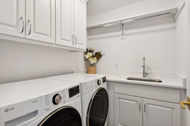 clothes washing area featuring washer and dryer, cabinets, and sink