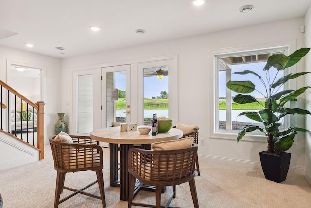 carpeted dining area with a water view