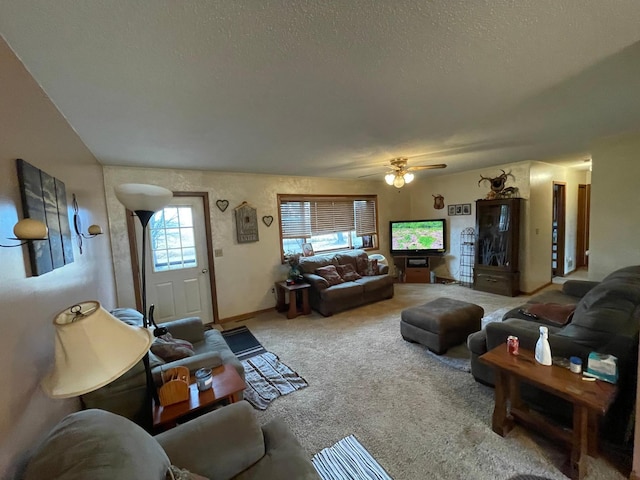 carpeted living room featuring ceiling fan and a textured ceiling