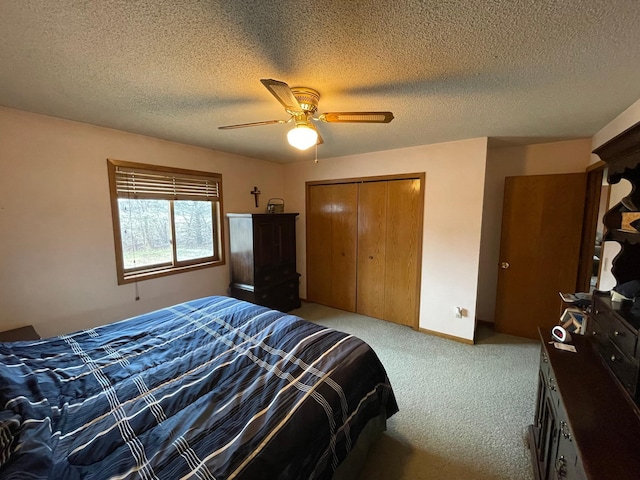 carpeted bedroom featuring a closet, ceiling fan, and a textured ceiling