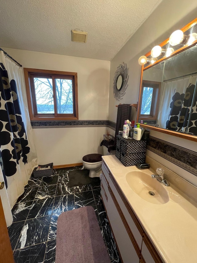 bathroom featuring vanity, toilet, curtained shower, and a textured ceiling