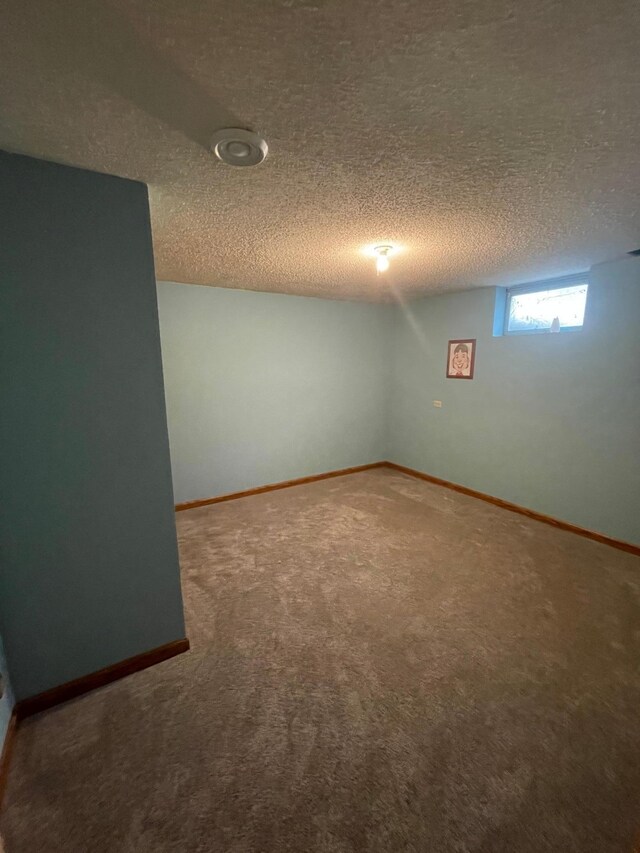 basement featuring carpet flooring and a textured ceiling