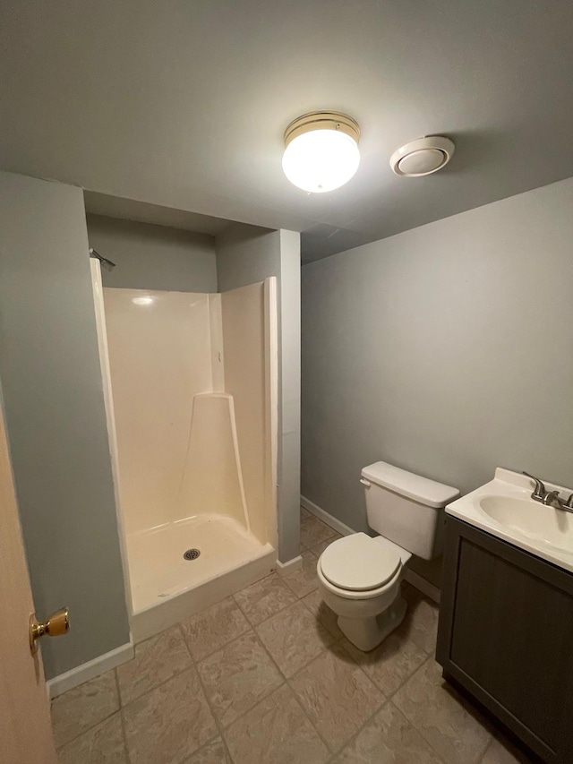 bathroom with tile patterned flooring, vanity, toilet, and walk in shower