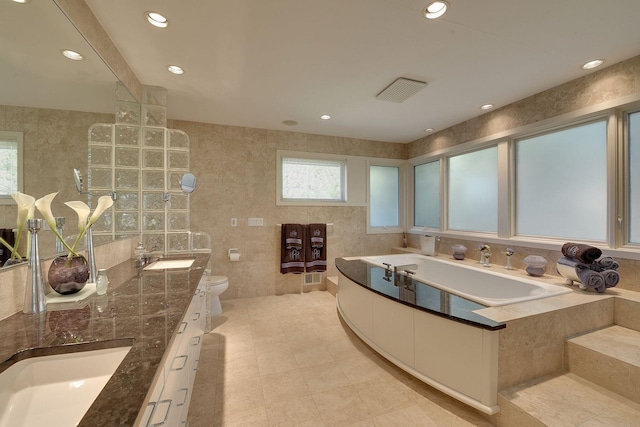 bathroom with tile patterned floors, toilet, vanity, and tile walls