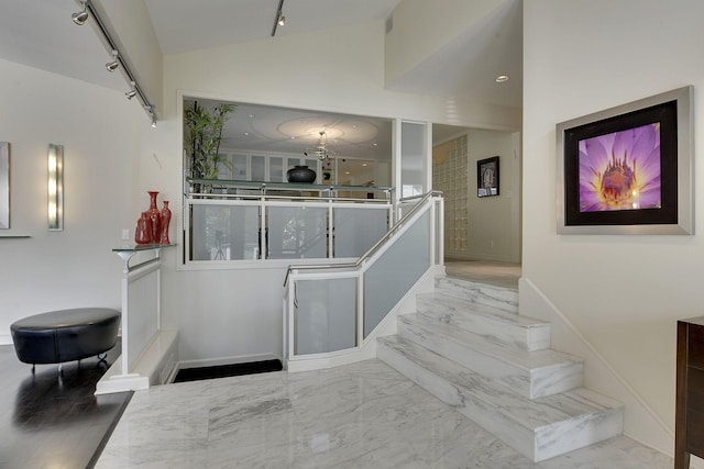 stairway with rail lighting and lofted ceiling