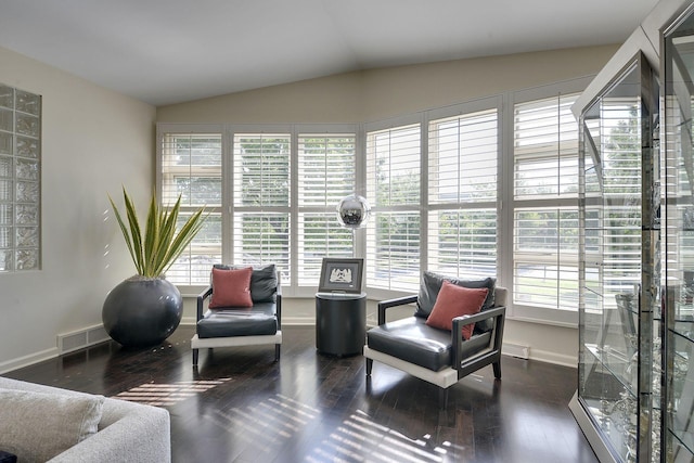 living area with plenty of natural light, dark wood-type flooring, and lofted ceiling