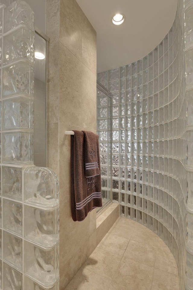 bathroom featuring tile patterned floors, a shower, and tile walls