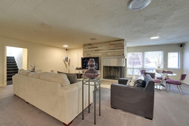 living room with a large fireplace, a textured ceiling, and carpet floors