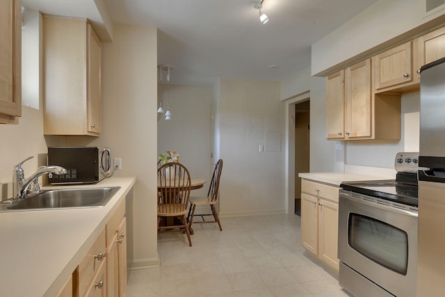 kitchen with sink, decorative light fixtures, light brown cabinetry, and appliances with stainless steel finishes