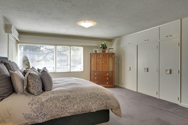 carpeted bedroom featuring a textured ceiling and a closet