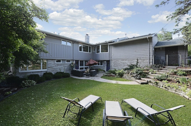 back of house with an outdoor living space, a patio, and a yard