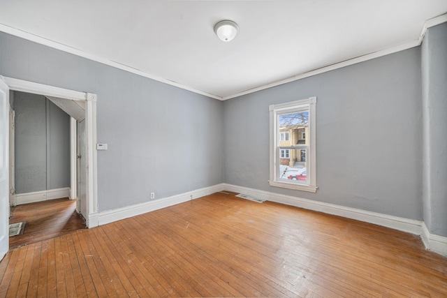 spare room featuring crown molding and hardwood / wood-style floors