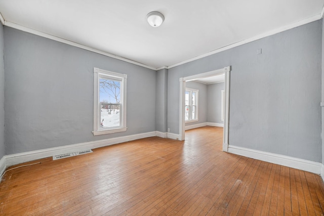 empty room featuring hardwood / wood-style flooring and ornamental molding