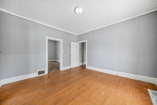 unfurnished bedroom with ornamental molding and wood-type flooring