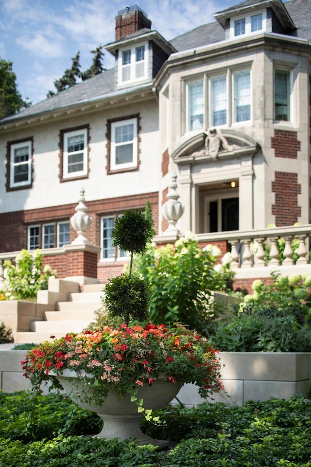 view of front of property featuring brick siding and a chimney