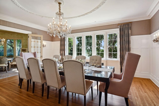dining room with a decorative wall, a chandelier, and a wainscoted wall