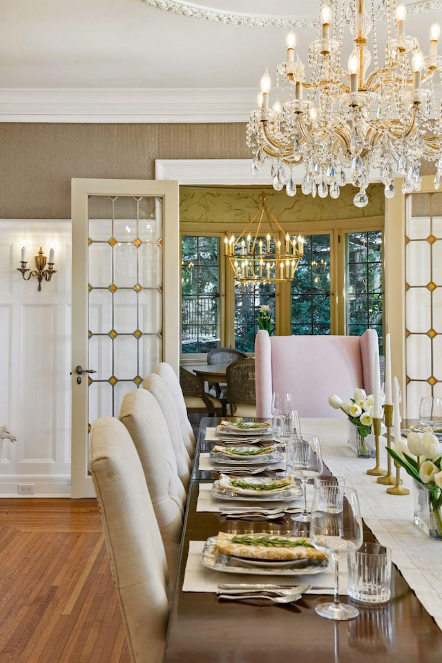 dining area with crown molding, a wealth of natural light, a notable chandelier, and wood finished floors