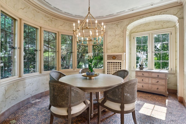 dining room with ornamental molding and a notable chandelier