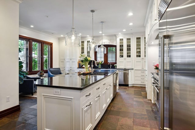 kitchen featuring a sink, dark countertops, stone tile floors, appliances with stainless steel finishes, and recessed lighting