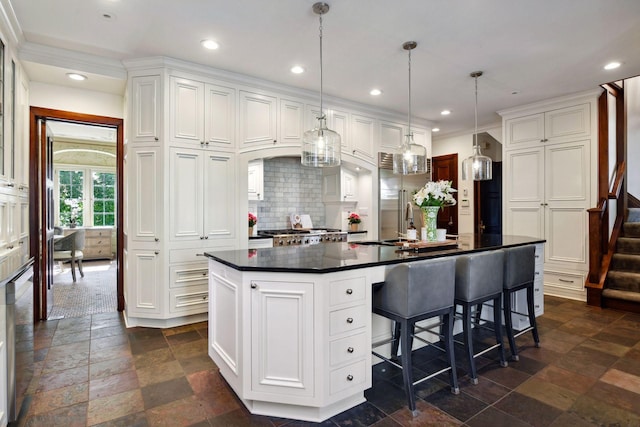 kitchen with recessed lighting, stone tile flooring, white cabinets, dark countertops, and tasteful backsplash