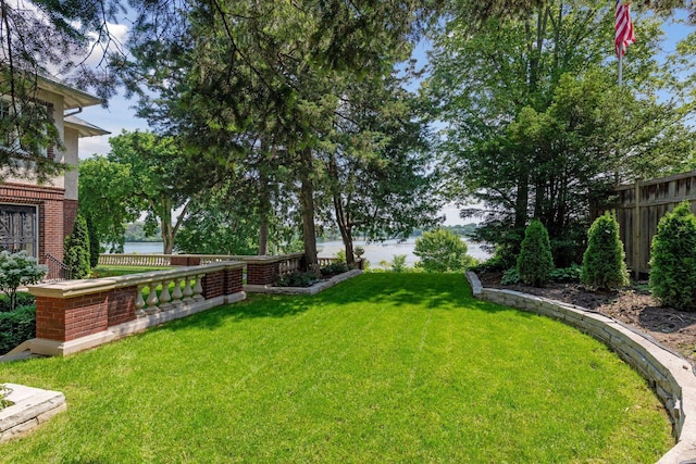 view of yard featuring fence and a water view