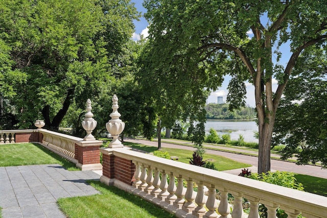 view of property's community with a water view and a lawn