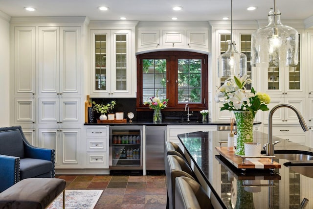 bar with a sink, indoor bar, stone tile flooring, wine cooler, and hanging light fixtures